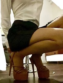 A mature business woman stands on the street and looks very sensual.